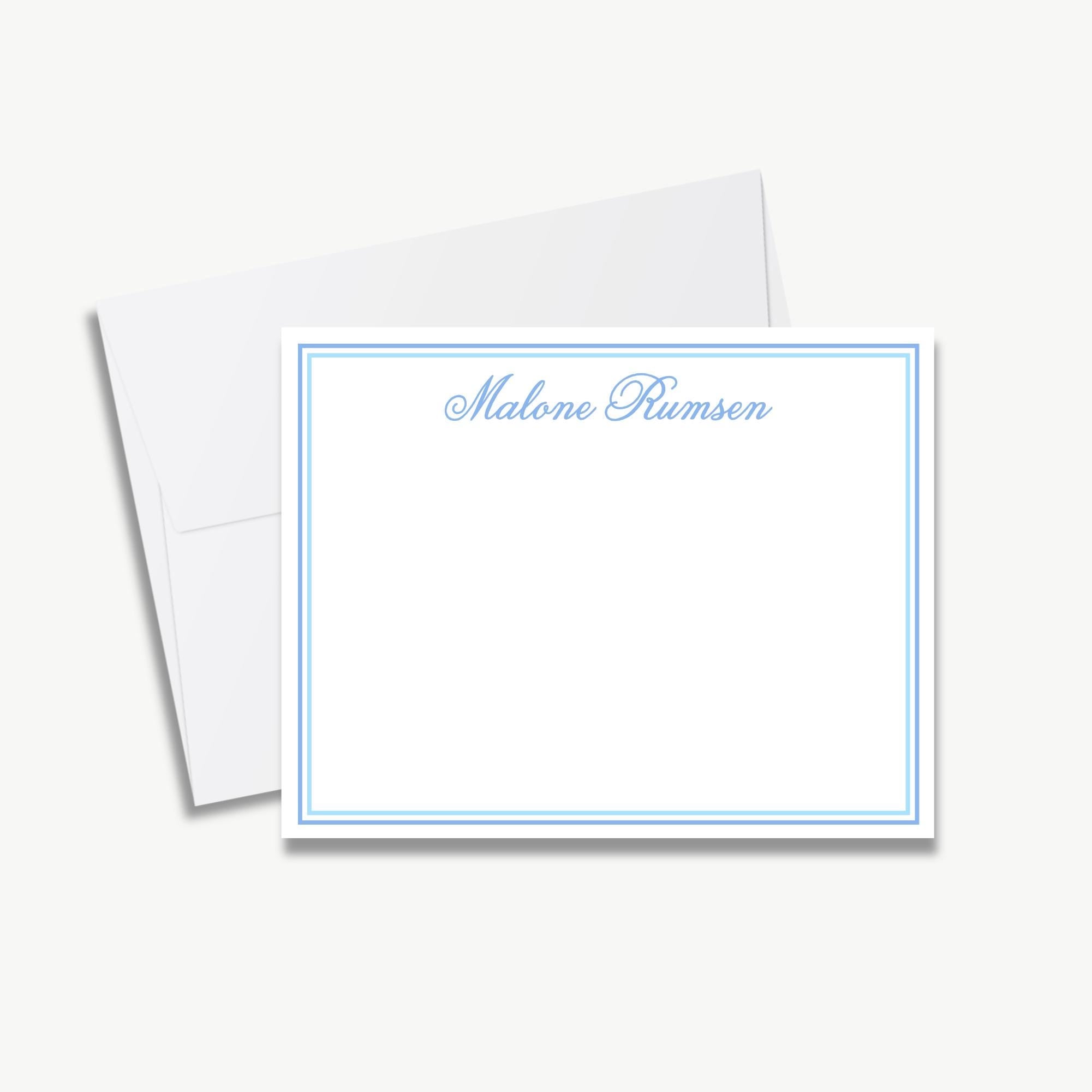 A blank white card with a blue border, placed on top of an envelope.