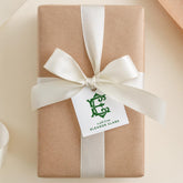 A gift wrapped in brown paper with a white ribbon and a green tag that reads "A gift from ELLA HARRIS CLARK".