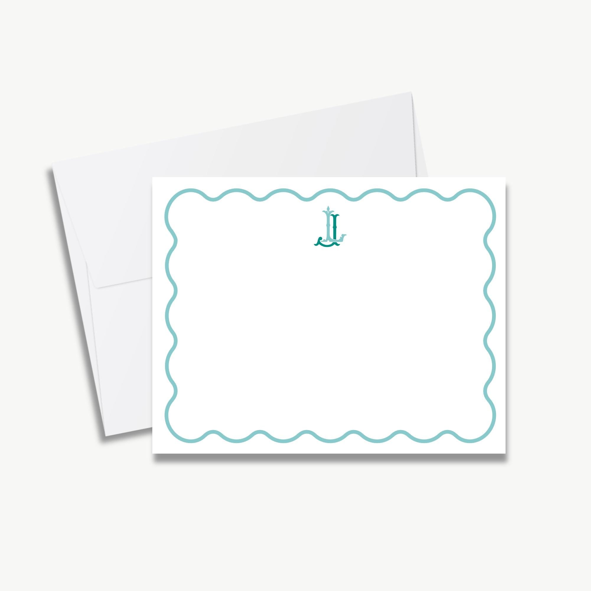 A white envelope with a scalloped edge and a teal border, featuring a monogrammed letter "J" in the center.