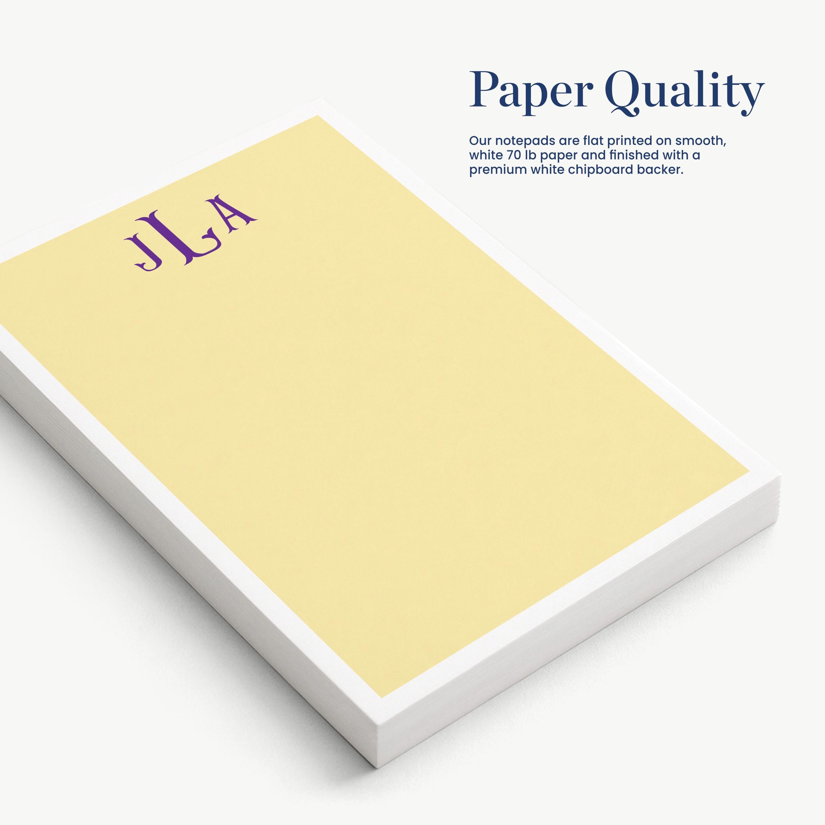 a yellow notepad with the initials "JLA" printed on it, placed on a white surface.