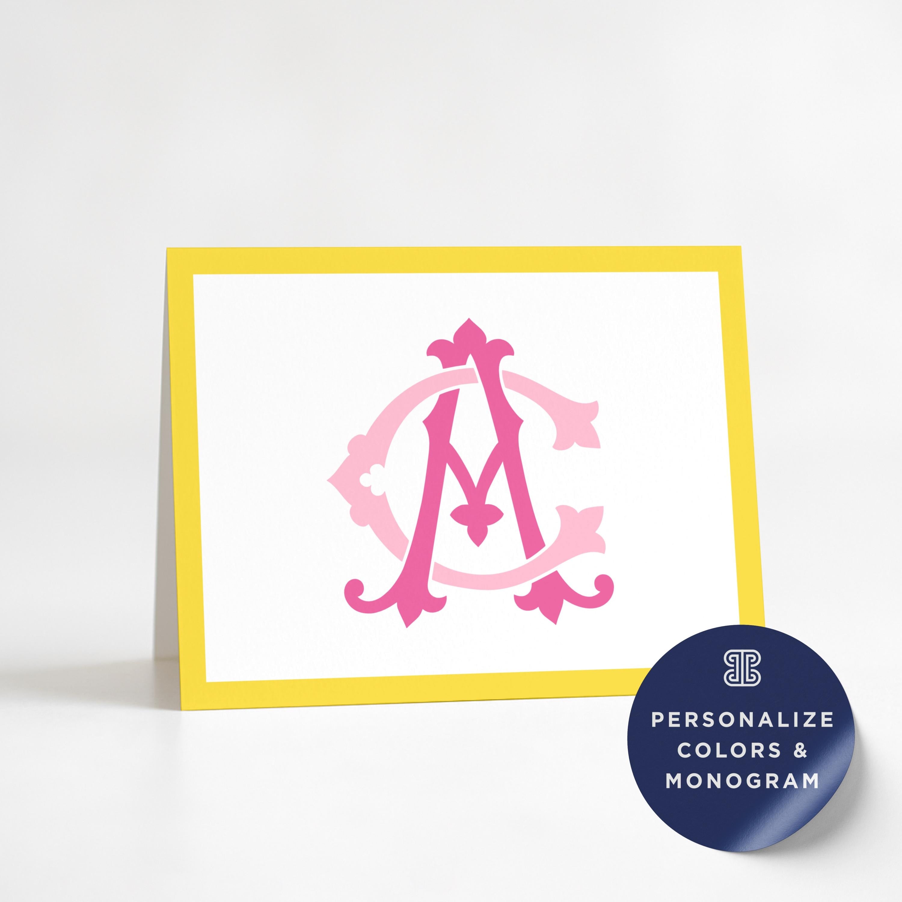 a yellow and white card with a pink monogram design on it.