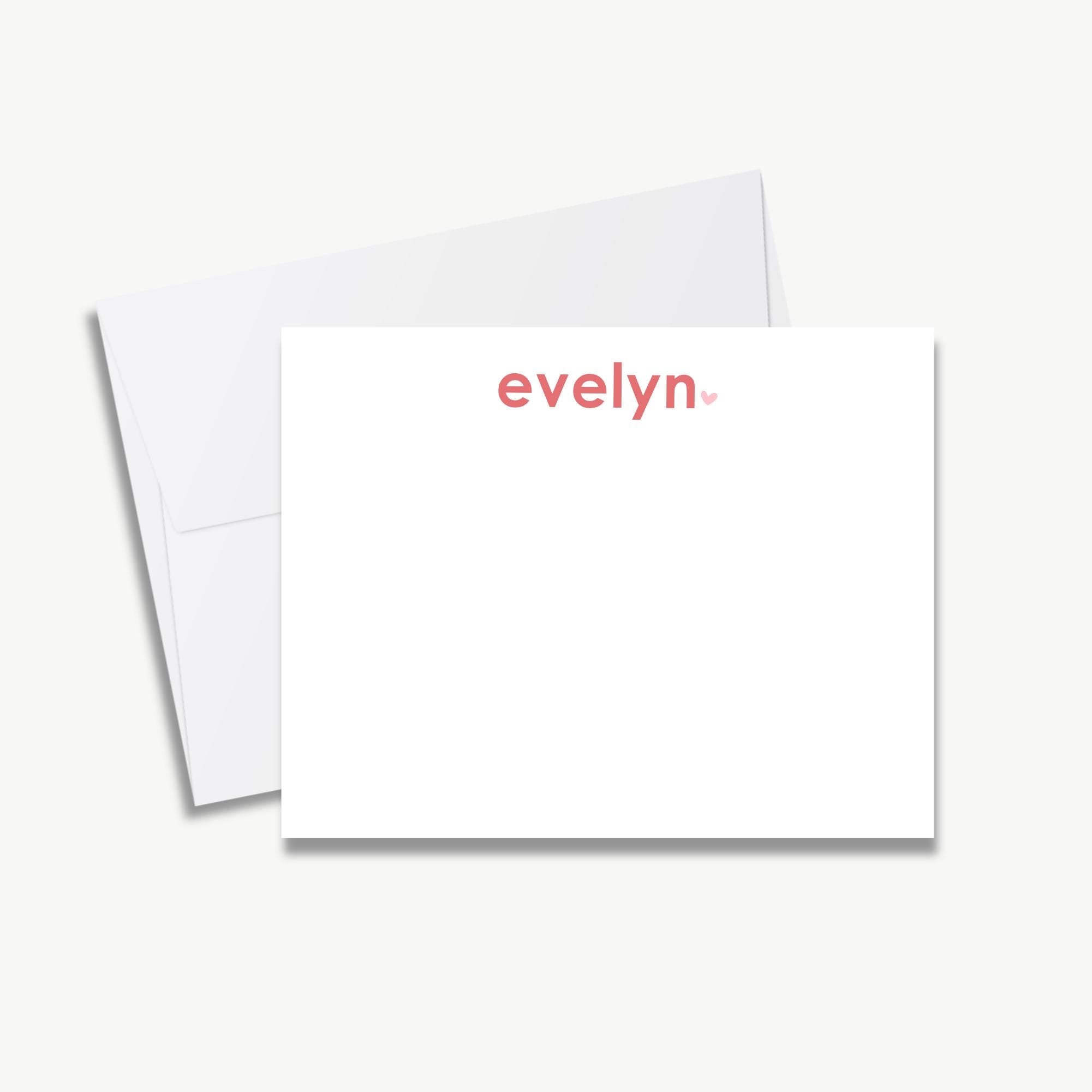 A white card with the name 'Evelyn' printed on it, along with a red heart symbol.