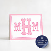 a pink greeting card with a large pink monogram of the initials 'M H M' on it.