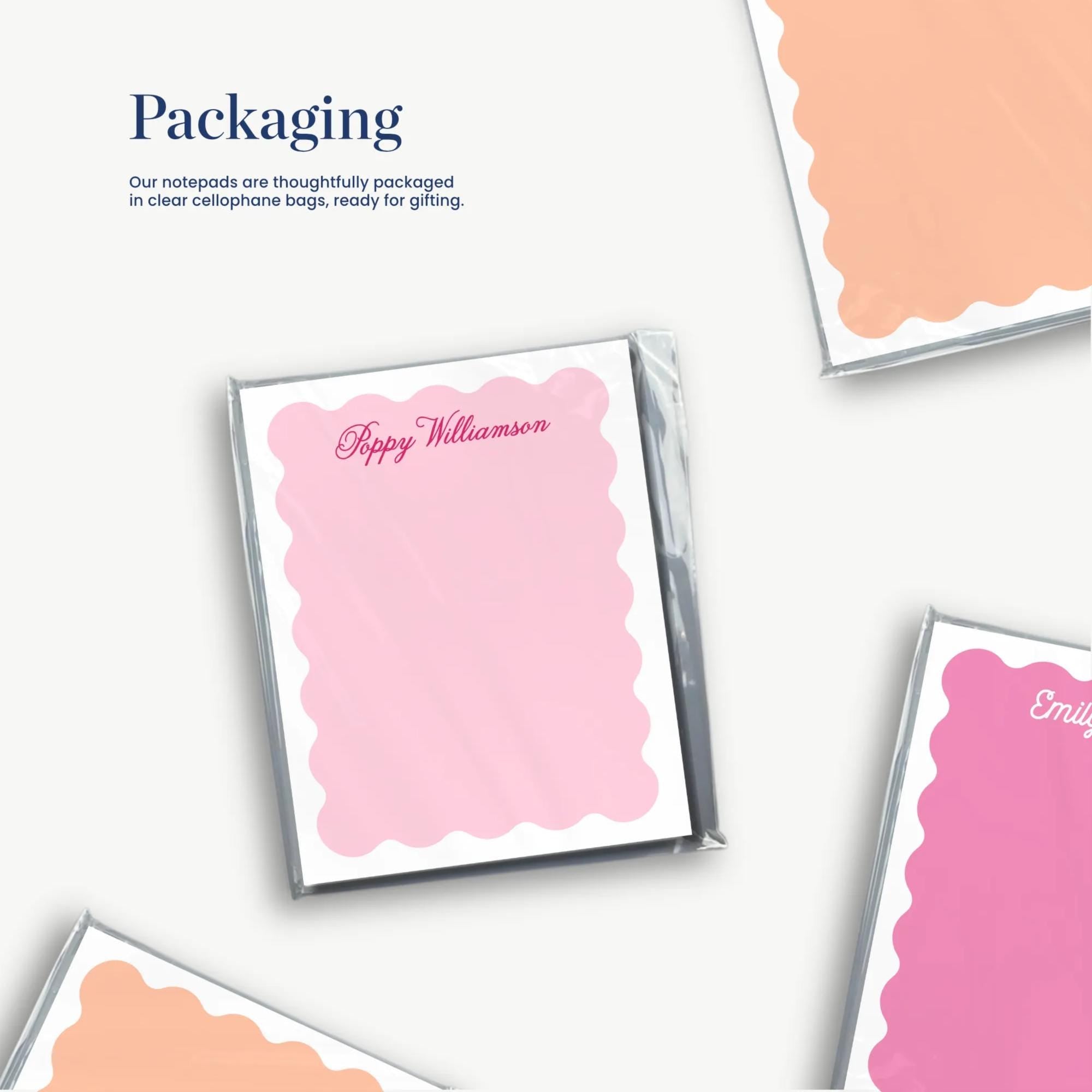 a collection of pink and orange scalloped paper notes, each with a name written on it, suggesting they are being packaged for gifting.