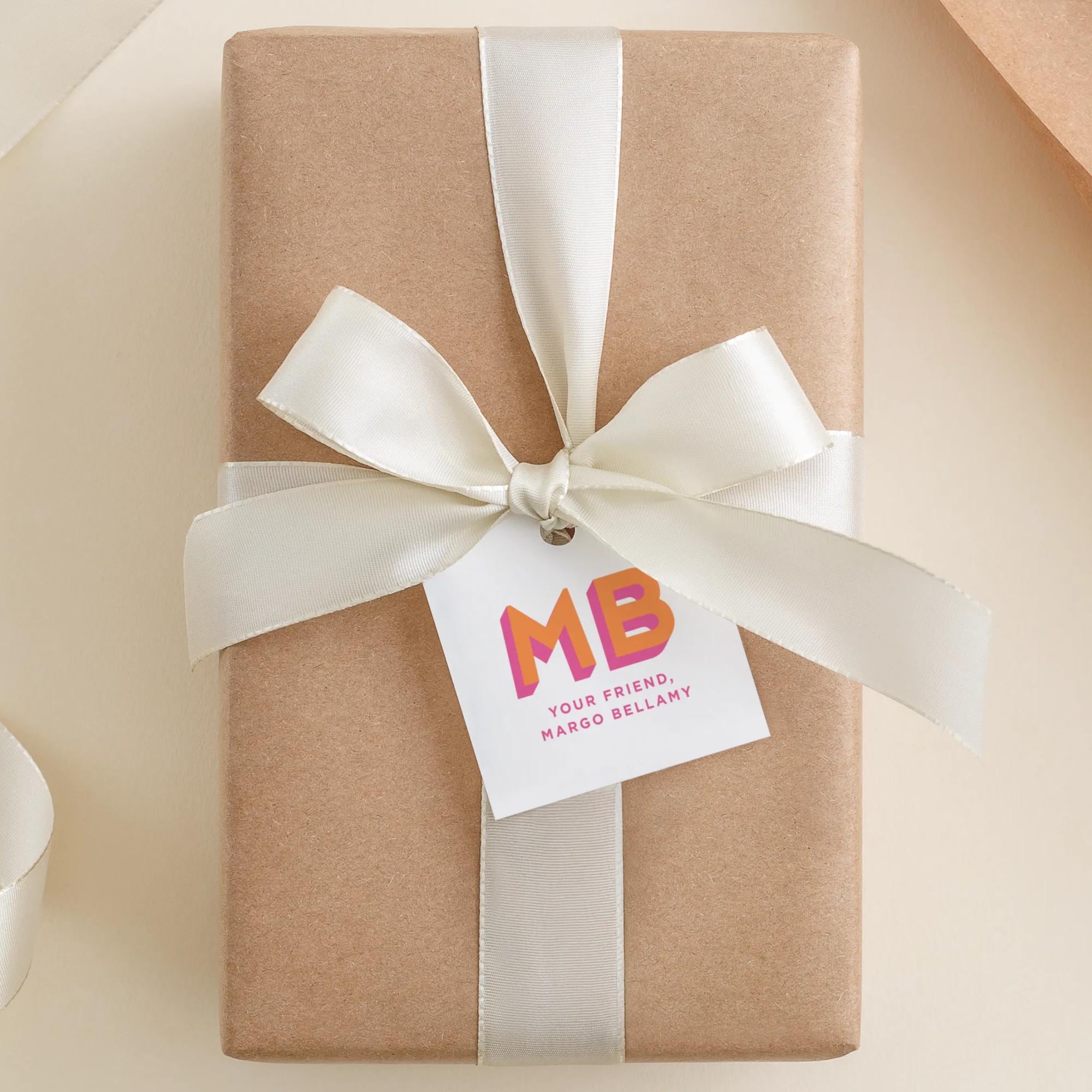A brown gift box with a white ribbon and a tag that reads "MB Your friend MARCO BELLANY".