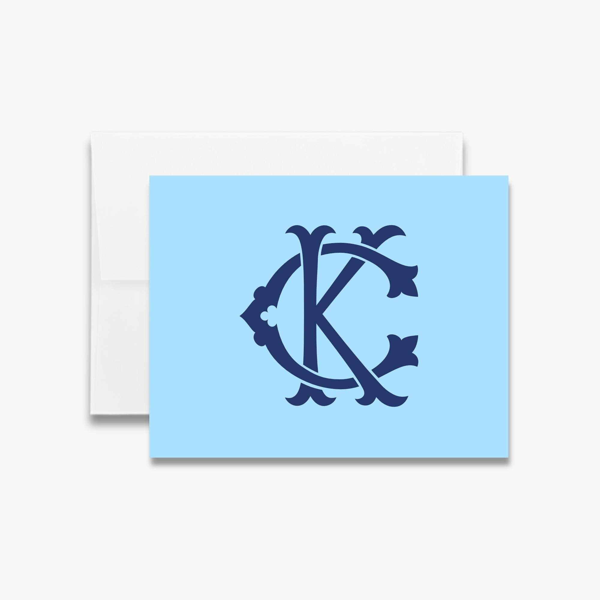 A light blue greeting card with a monogram design featuring the letters 'CK' in a decorative style.
