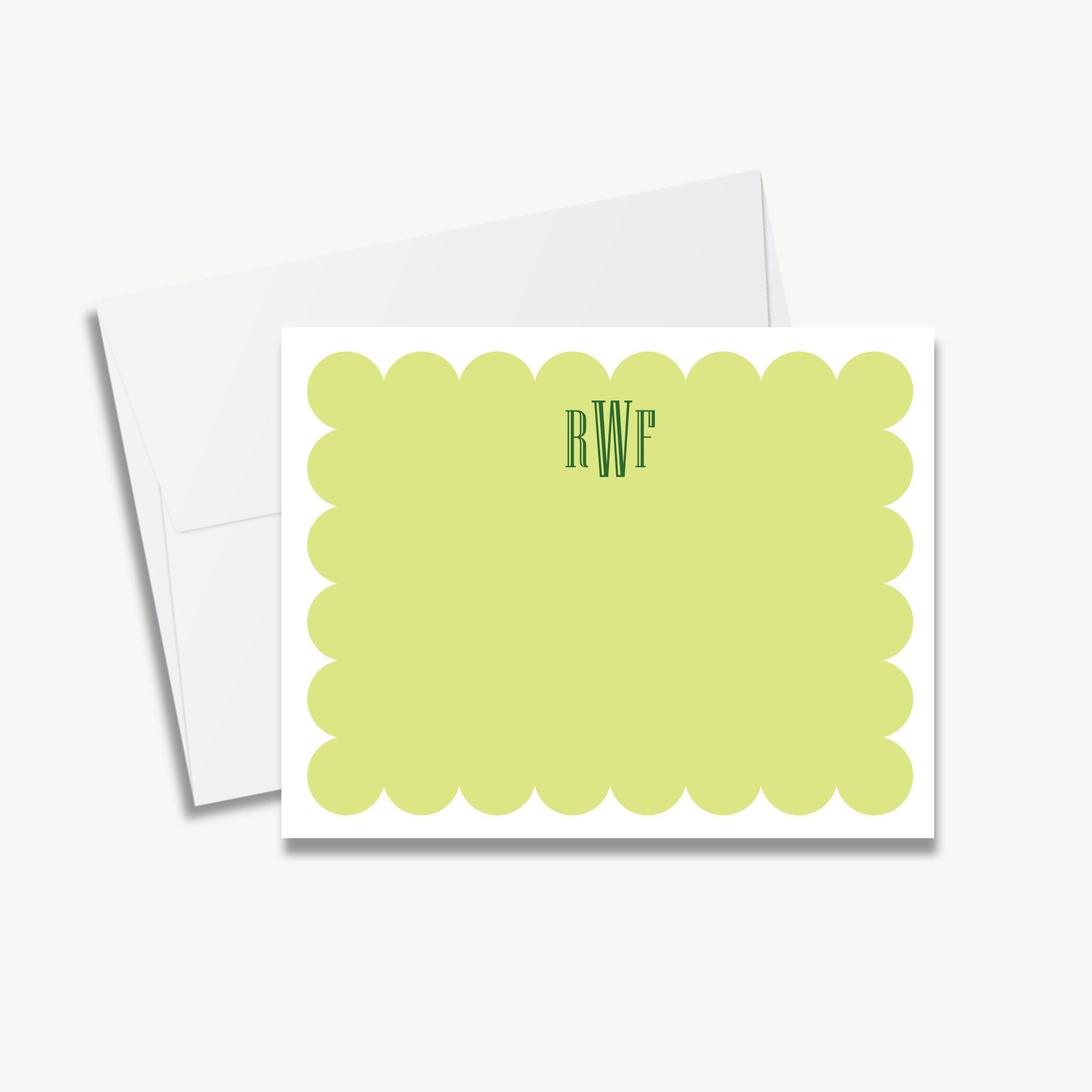 a white envelope with a green scalloped edge and a blank card with a scalloped edge in the center.