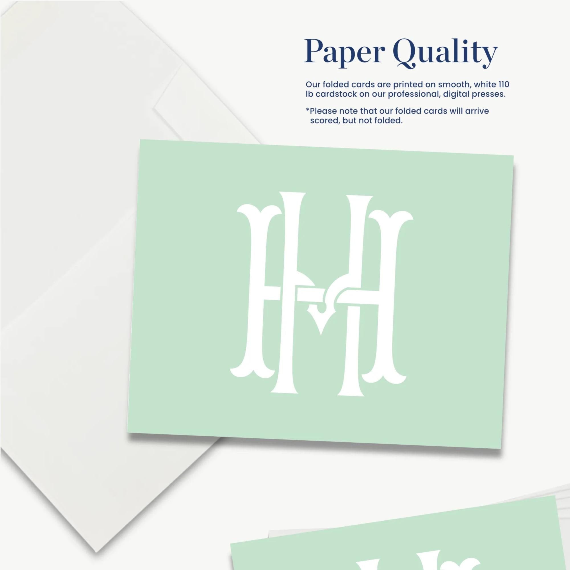 a set of green cards with a monogram design, and there is a white envelope in the background.