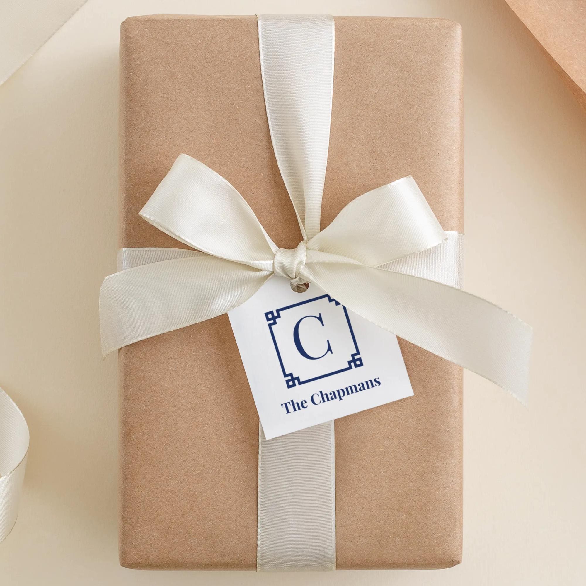A brown gift box with a white ribbon and a tag that says "The Chapmans"