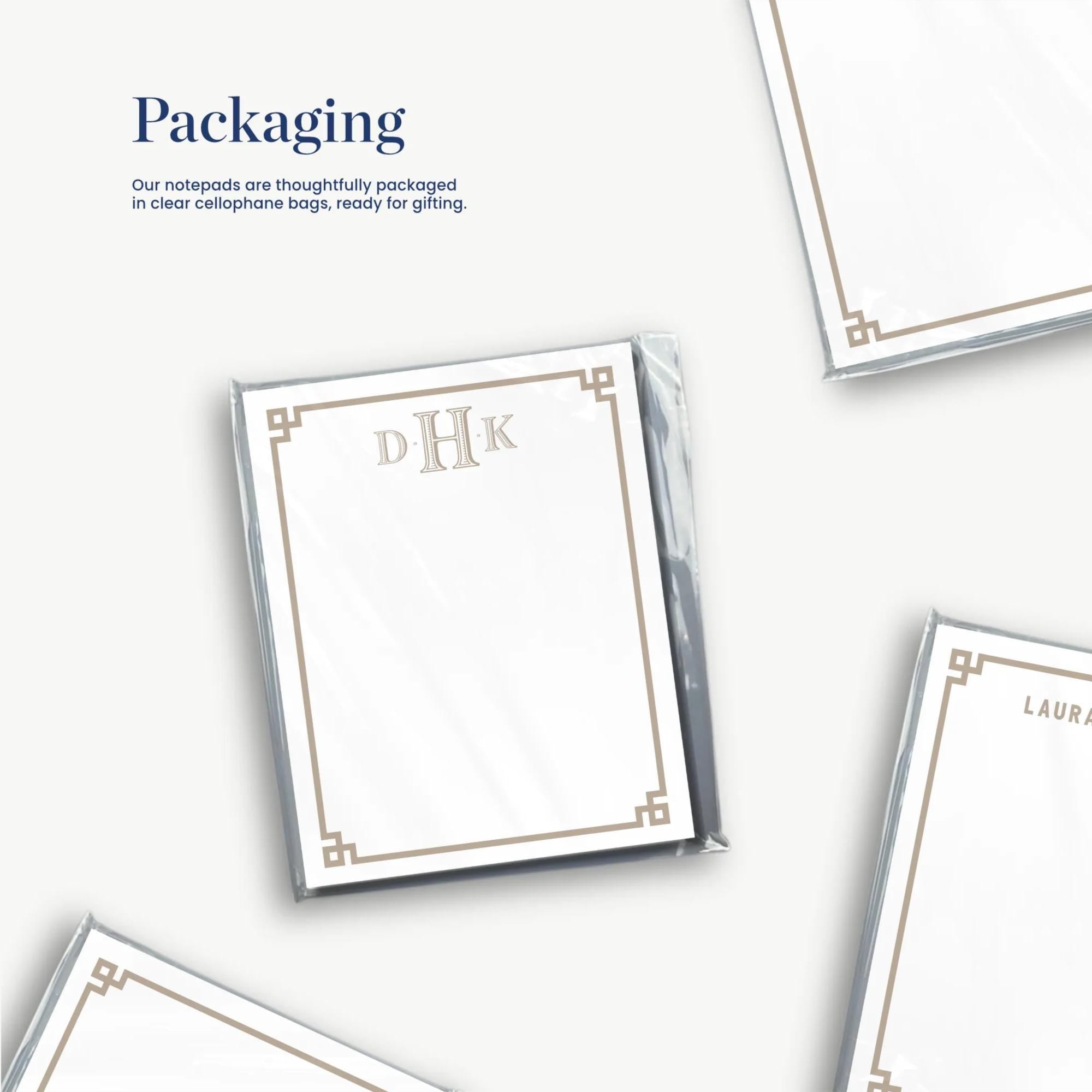 several blank stationery items, including a personalized note card with the initials "DHK" and a note card with the name "LAURA KNOWLES". The stationery items are arranged in a way that suggests they are being packaged for gift-giving purposes.