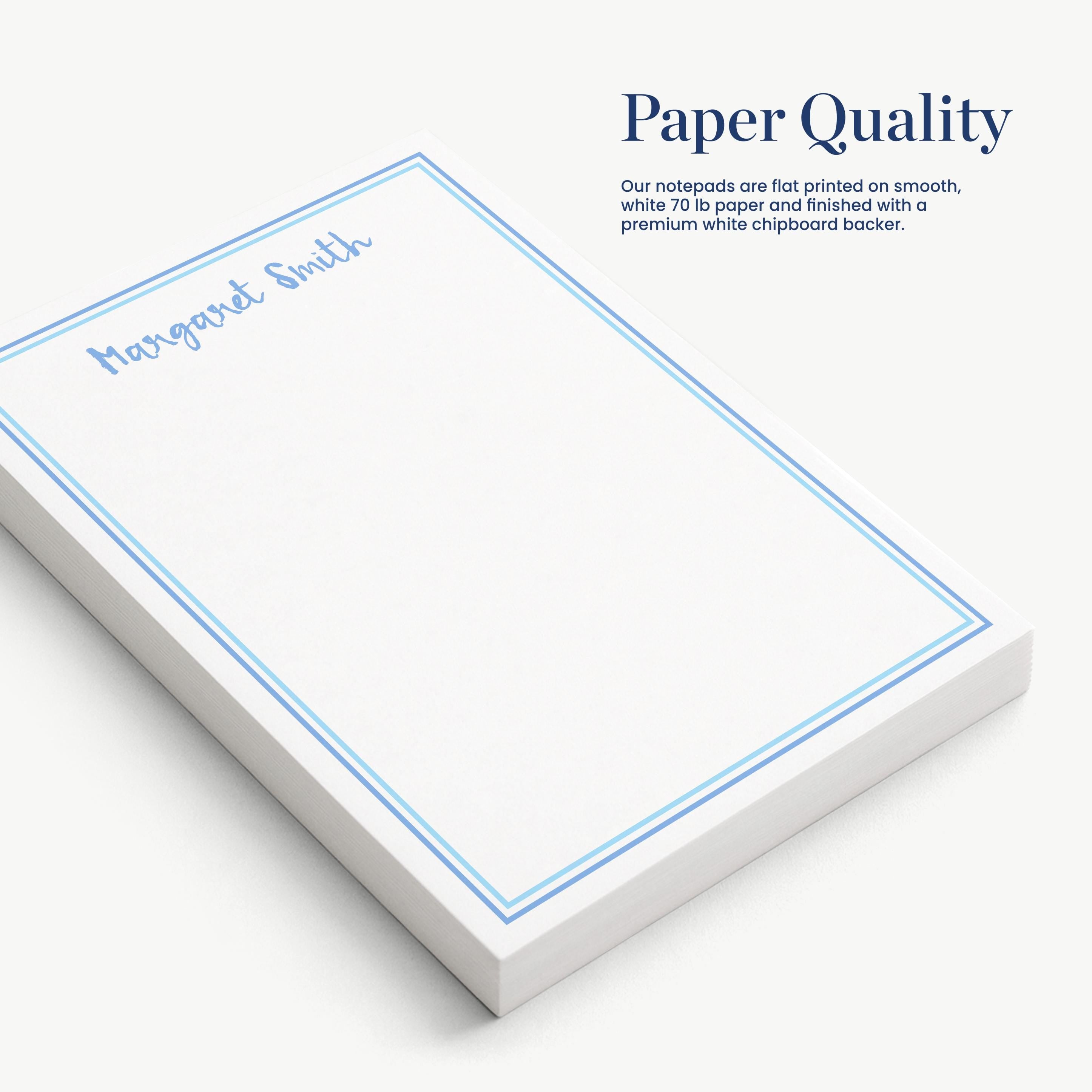 a set of white notepads with blue borders, arranged on a white surface.