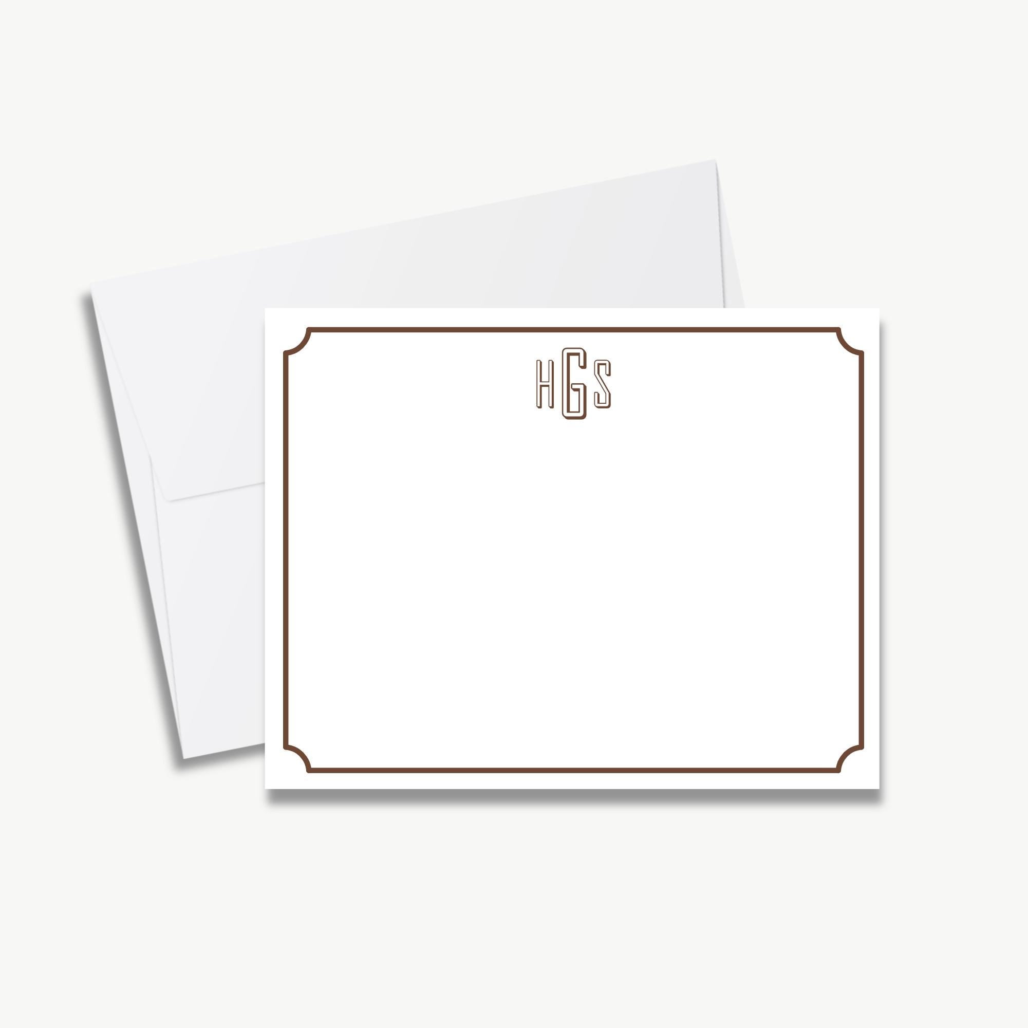 a blank white card with a brown border, placed on top of an envelope.