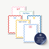 a collection of personalized stationery items, including name cards and monogrammed designs. The stationery items feature scalloped edges and monogrammed initials or names, such as 'KT', 'Lily Hughes', 'ARB', 'Emmy Foster', and 'H M'. The stationery items are arranged in a row, showcasing the variety of designs available for customization.