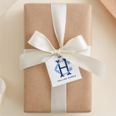 A brown gift box with a white ribbon and a tag that reads "Collins Harris".