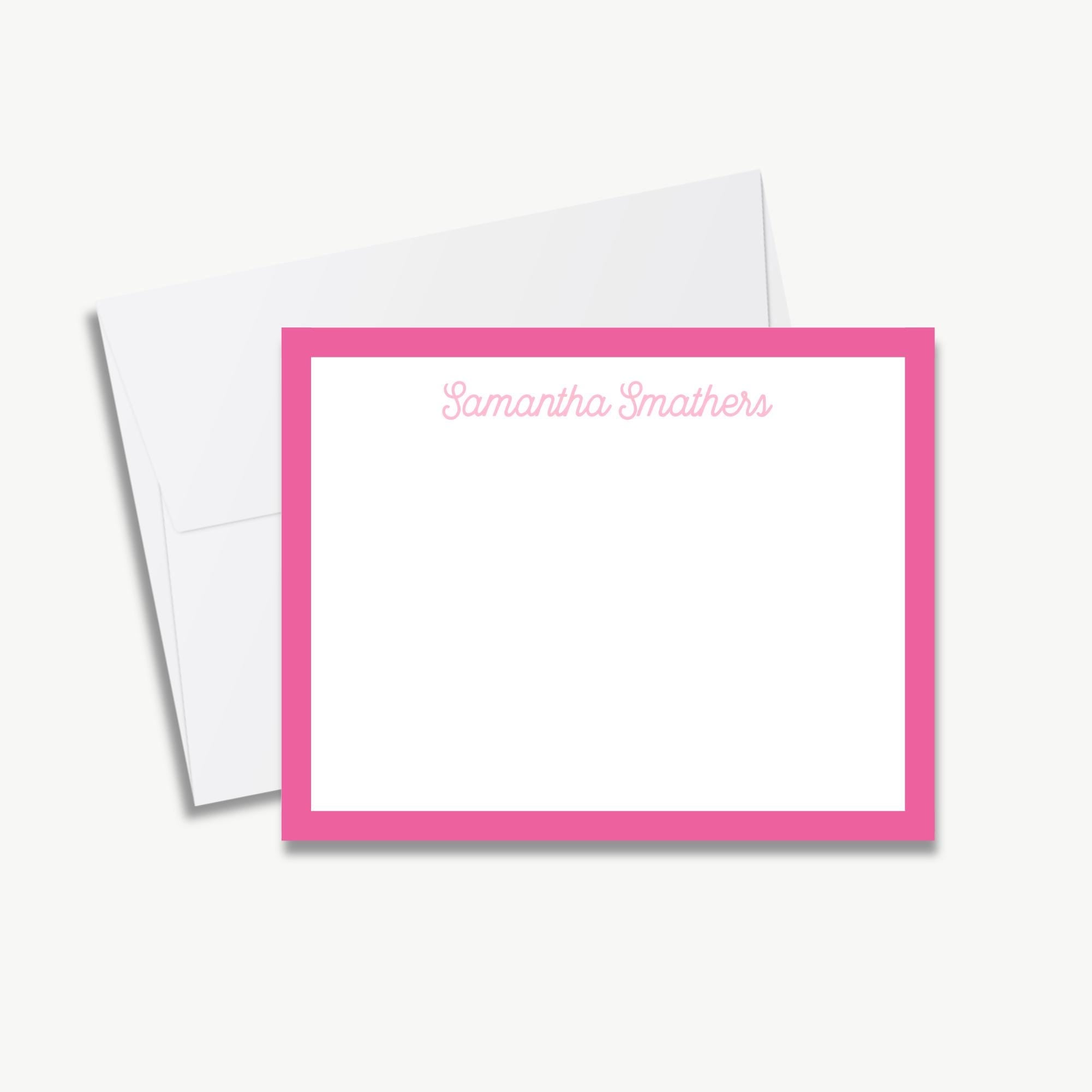 A pink-bordered personalized note card with a blank space for writing, placed next to an envelope.