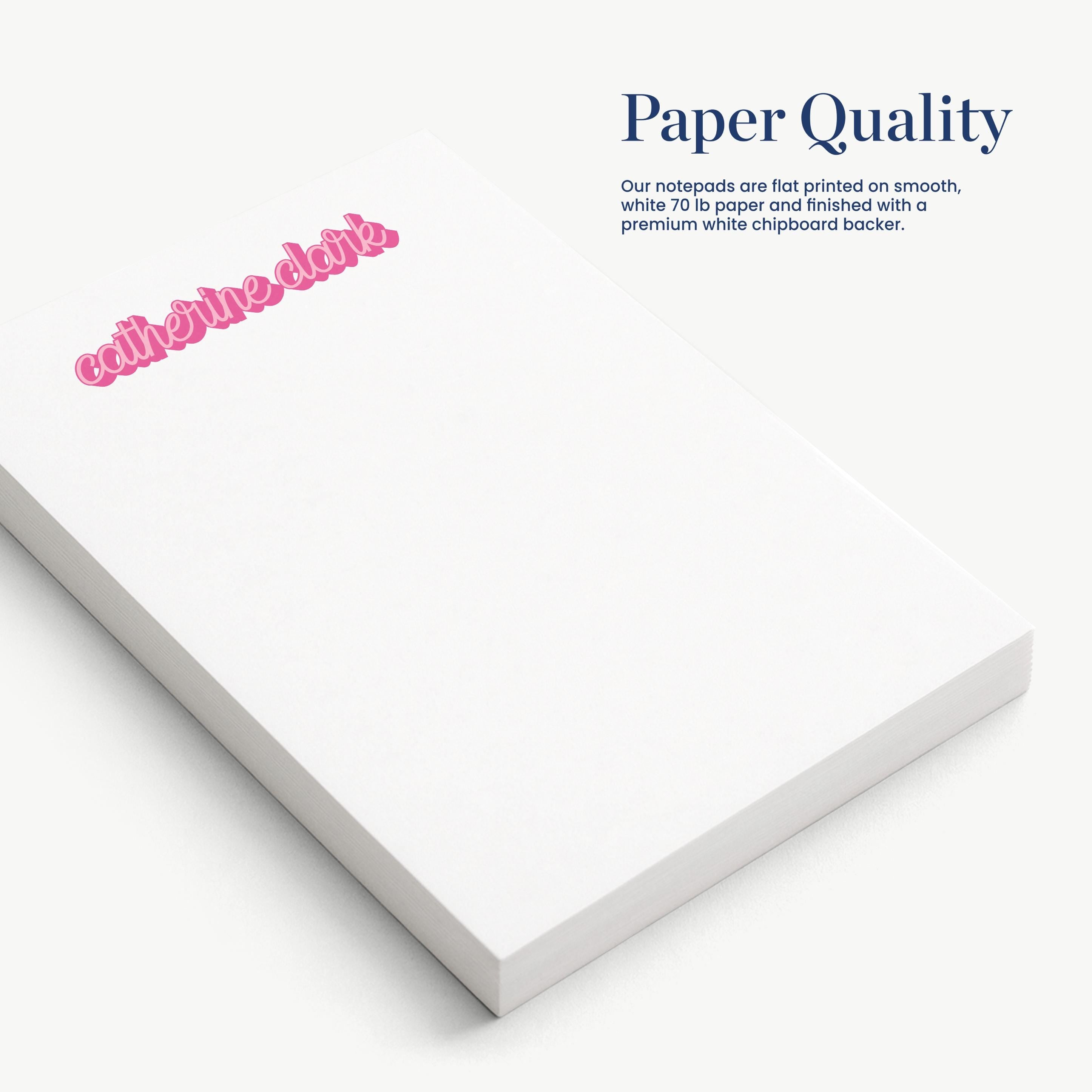 a close-up view of a white notepad with a pink text logo on it.