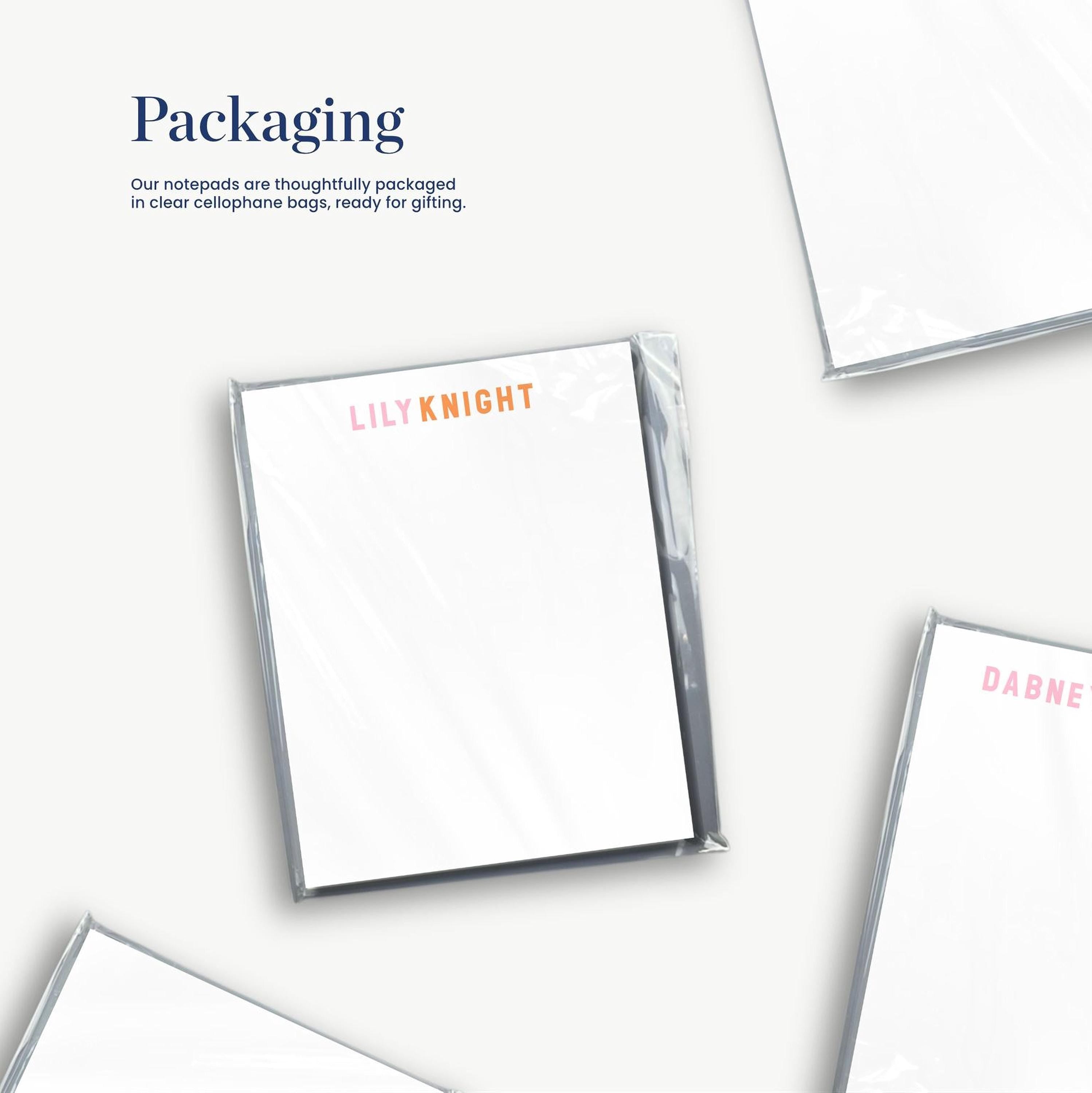 several white notepads with the word "Lily Knight" printed on them, along with some text that reads "Packaging" and "Our notepads are thoughtfully packaged in clear cellulophone bags, ready for gifting."