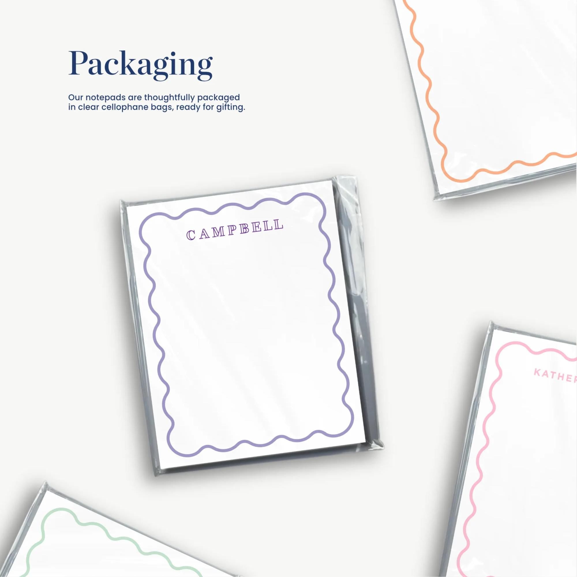 a collection of various shapes and patterns, including a note pad with a purple border, a note pad with a pink border, and a note pad with a green border. The note pads appear to be used for packaging purposes, as indicated by the text "Packaging" and "Our notebooks are carefully packaged in clear cellophane bags, ready for gifting."