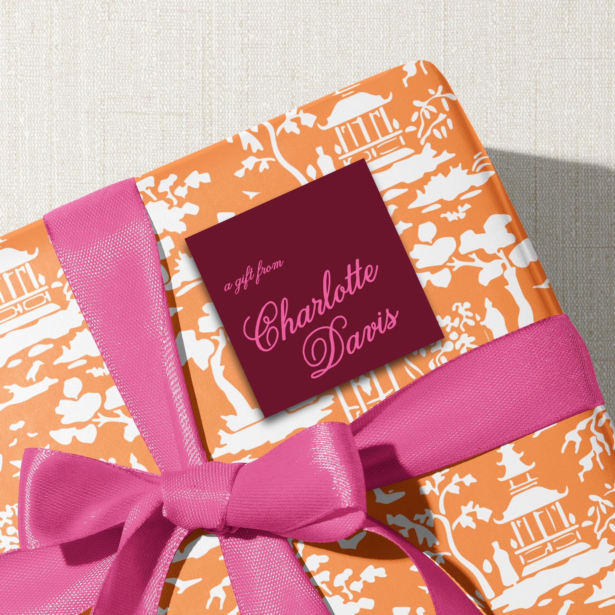 A gift wrapped in a paper with a bow and a tag that reads "a gift from Charlotte Davis".