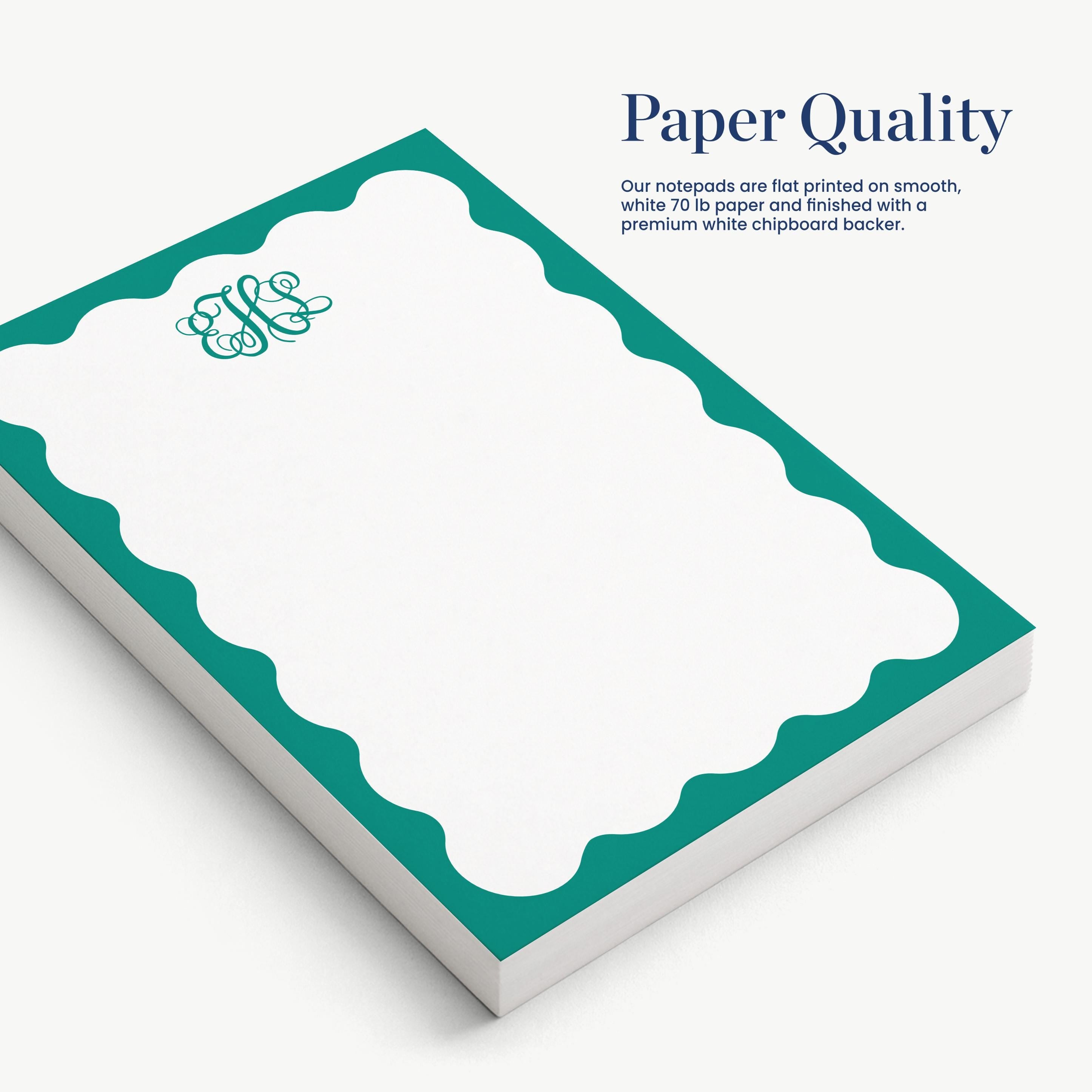 a set of green and white notepads with a scalloped edge, arranged on a white background.