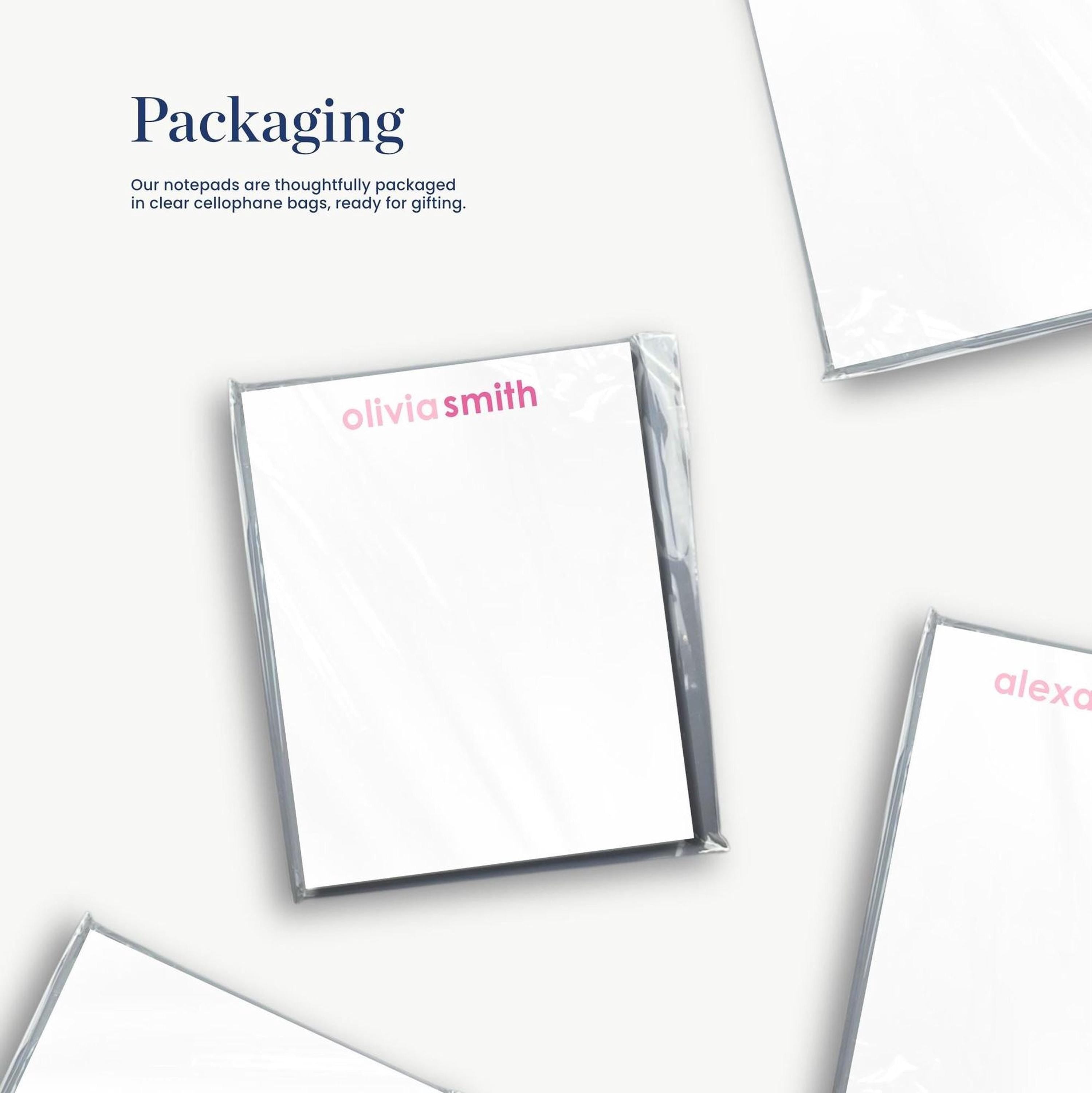 several white notepads with the name 'olivia smith' printed on them, along with some packaging materials.