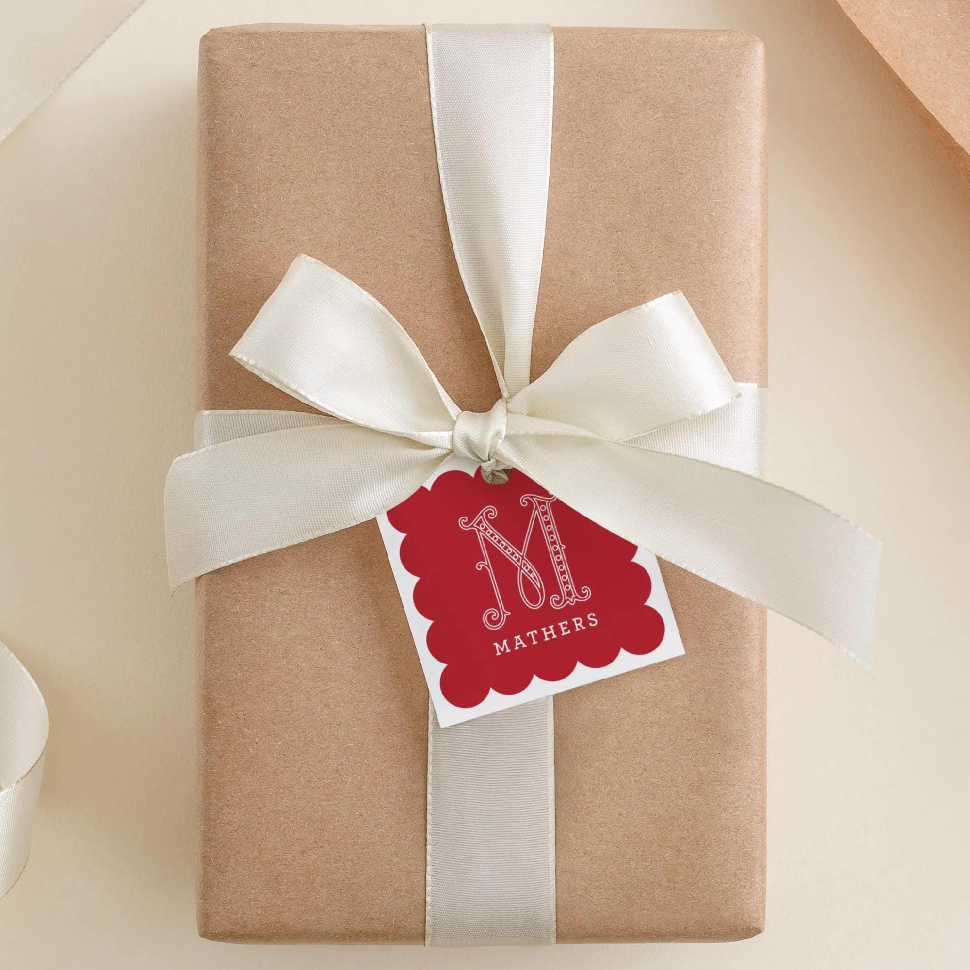 A brown gift box with a white ribbon and a red tag that says "MATHERS" attached to it.