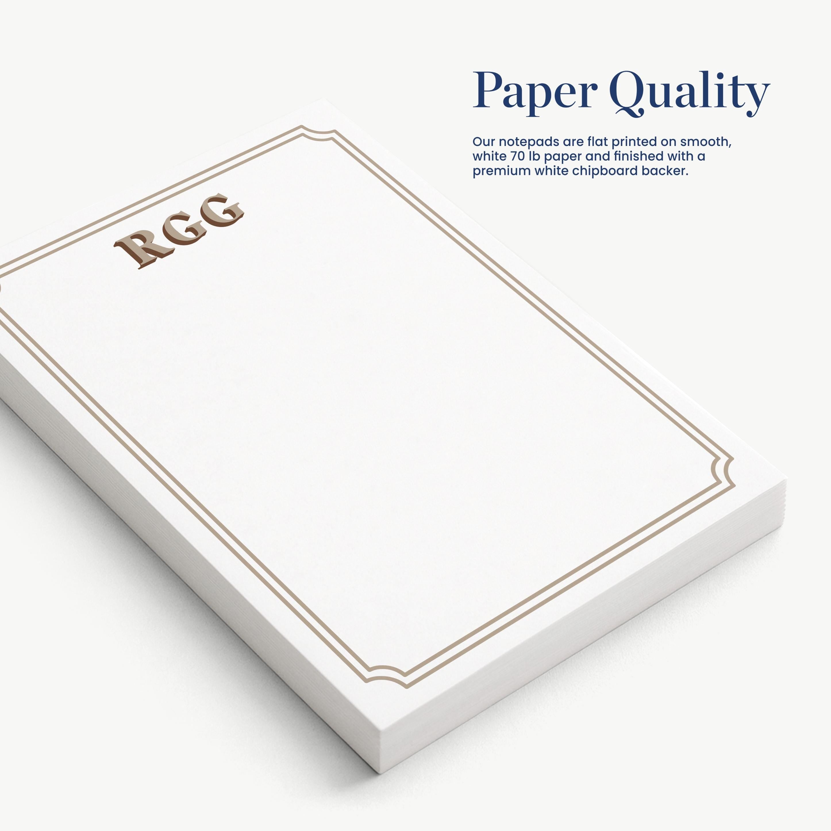 a set of white notepads with a gold border, arranged on a white surface.