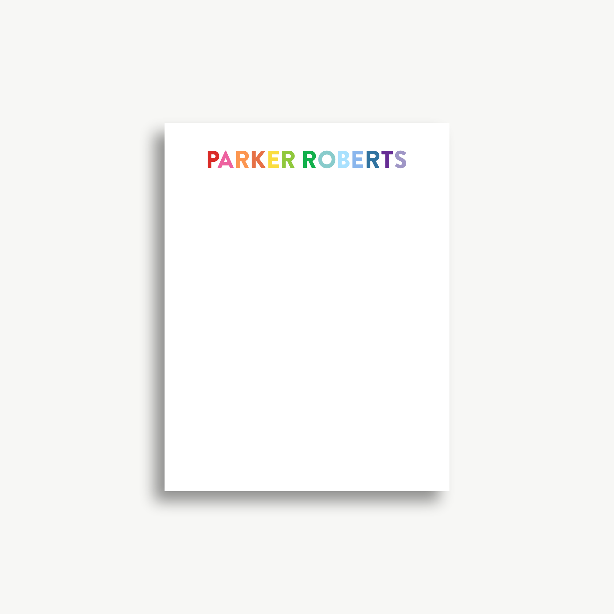 A white piece of paper with the name 'Parker Roberts' written on it in rainbow colors.