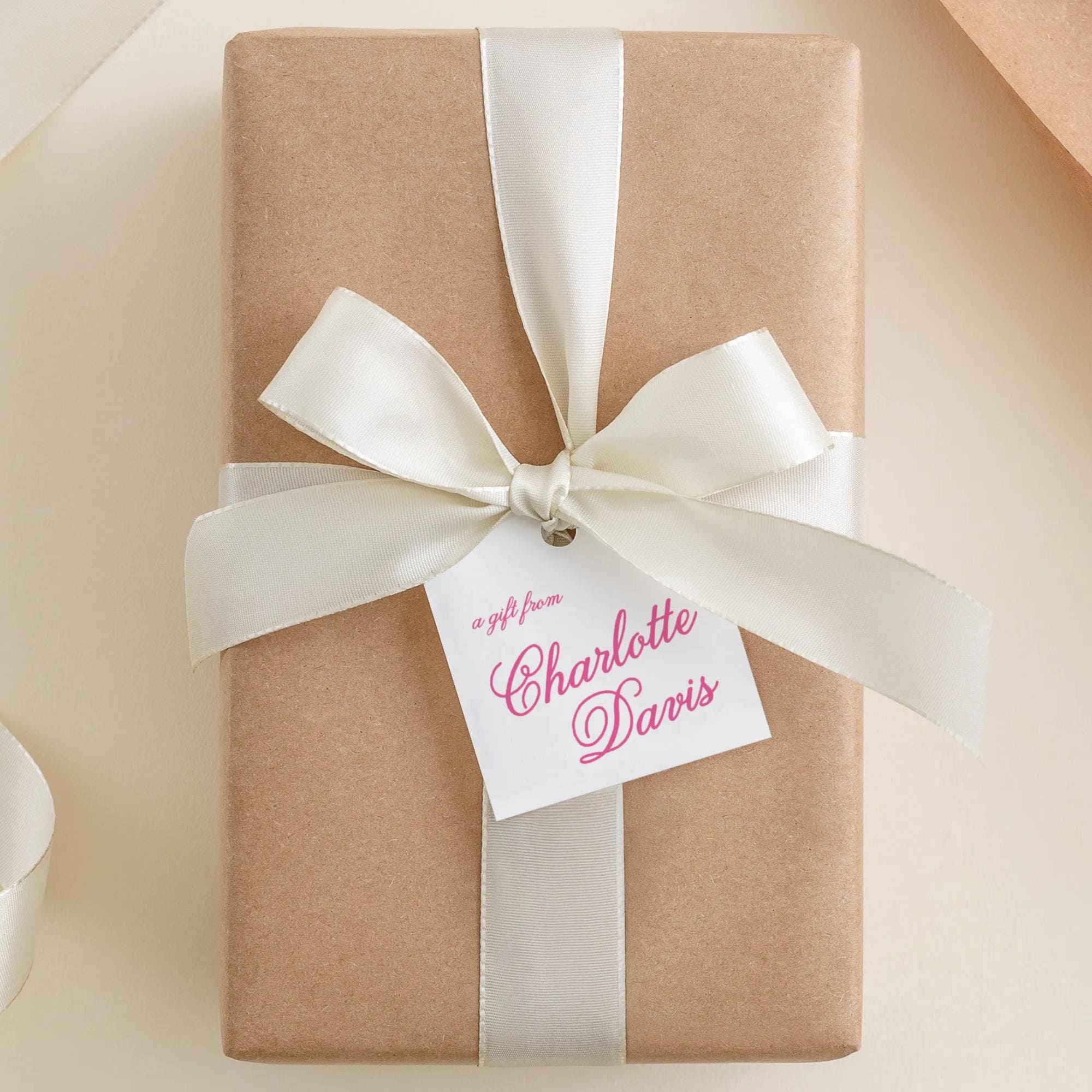 A gift wrapped in brown paper with a white ribbon and a tag that says "a gift from Charlotte Davis".