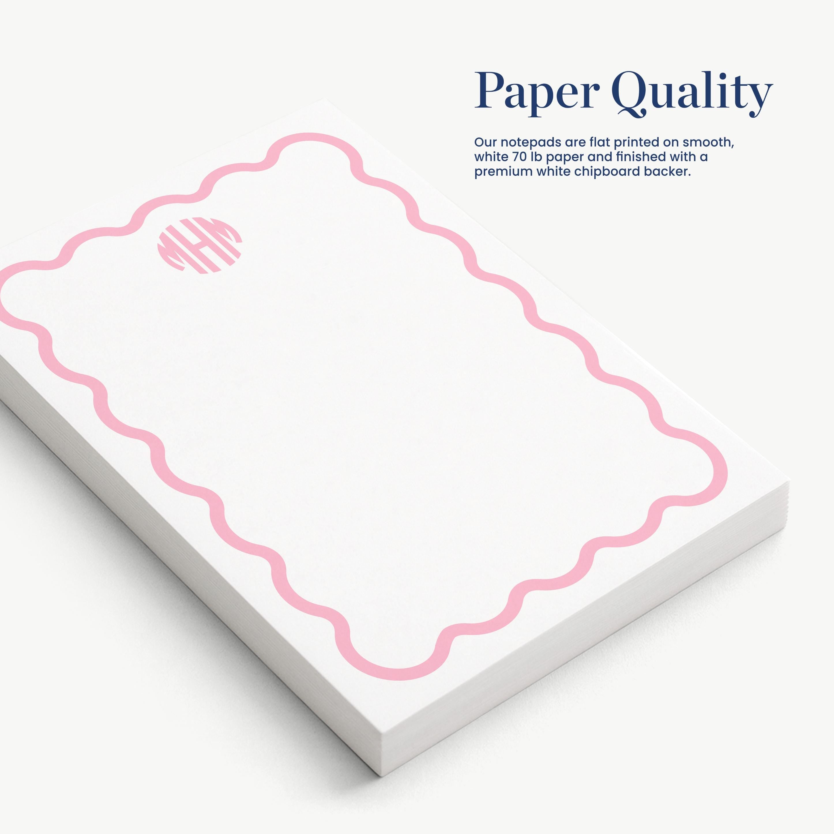 a set of white notepads with a pink wavy border design.